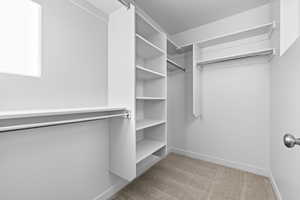 Spacious closet with light colored carpet