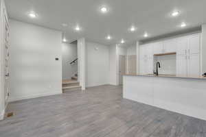 Kitchen with open floor plan, visible vents, a sink, and white cabinetry