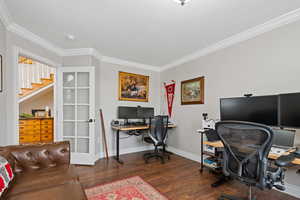 Office with dark wood-style floors, ornamental molding, and baseboards