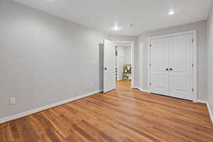 Unfurnished bedroom with a closet, light wood-style flooring, and baseboards