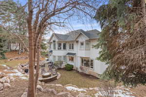 View of front of home featuring a patio area, roof with shingles, and stucco siding