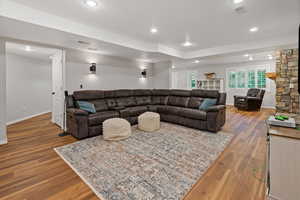 Living room featuring baseboards, visible vents, wood finished floors, and recessed lighting