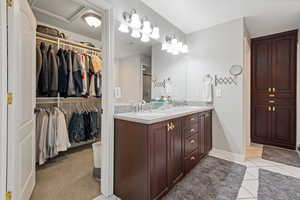 Full bath with double vanity, tile patterned flooring, baseboards, and a sink