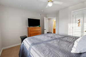 Bedroom featuring light carpet, a ceiling fan, visible vents, and baseboards