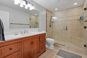 Full bathroom featuring visible vents, toilet, vanity, a shower stall, and tile patterned flooring