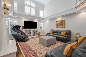 Living room featuring crown molding, dark wood finished floors, a towering ceiling, and baseboards