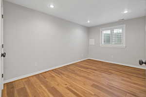 Empty room with light wood-type flooring, baseboards, visible vents, and recessed lighting