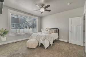 Bedroom featuring a ceiling fan, carpet, visible vents, and baseboards