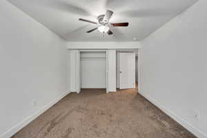 Unfurnished bedroom featuring a ceiling fan, carpet, baseboards, and a textured ceiling