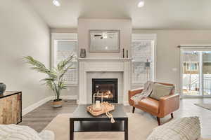 Living area featuring light wood-style floors, recessed lighting, baseboards, and a tiled fireplace