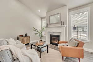 Living area featuring light wood-style floors, a tile fireplace, and plenty of natural light