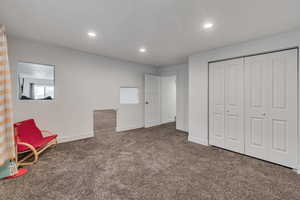 Interior space featuring baseboards, dark colored carpet, and recessed lighting