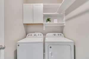 Laundry room featuring washing machine and dryer and cabinet space