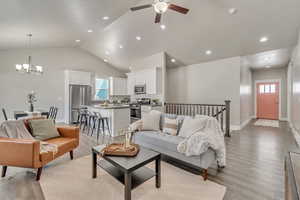 Living room with lofted ceiling, plenty of natural light, light wood finished floors, and recessed lighting