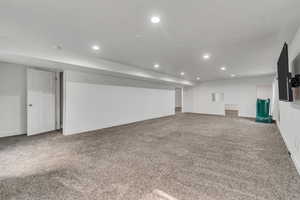 Finished basement featuring baseboards, a textured ceiling, carpet, and recessed lighting