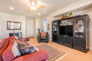 Living area featuring ceiling fan, baseboards, light colored carpet, and recessed lighting