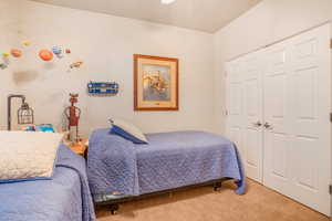 Carpeted bedroom with a closet