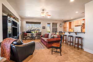 Living area featuring light tile patterned floors, recessed lighting, visible vents, ceiling fan, and baseboards