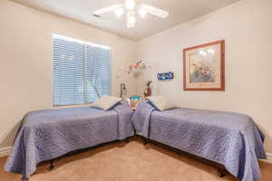 Bedroom with carpet floors, visible vents, and a ceiling fan