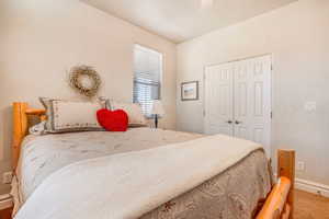 Carpeted bedroom with baseboards, a ceiling fan, and a closet