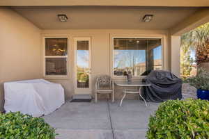 View of exterior entry with a patio and stucco siding