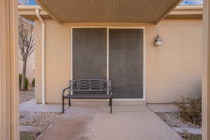 Entrance to property with a patio area and stucco siding