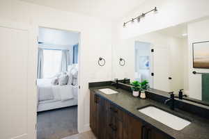 Bathroom featuring double vanity, a sink, toilet, and ensuite bathroom