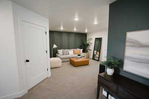 Living room with light carpet, a decorative wall, and recessed lighting