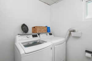 Clothes washing area featuring laundry area and washing machine and dryer