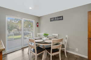 Dining space with wood finished floors, visible vents, and baseboards