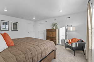 Bedroom with recessed lighting, visible vents, and light colored carpet