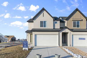 View of front of house with a garage, a residential view, driveway, and a shingled roof