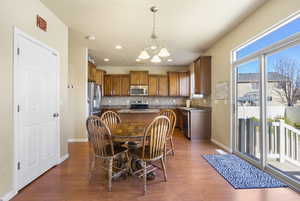 Dining space with a notable chandelier, recessed lighting, wood finished floors, and baseboards