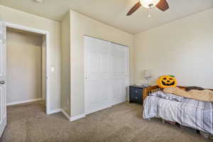 Bedroom featuring a ceiling fan, baseboards, a closet, and light colored carpet