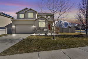 View of front of home featuring a mountain view, a garage, fence, concrete driveway, and a front yard