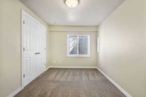 Unfurnished bedroom with carpet floors, visible vents, and baseboards