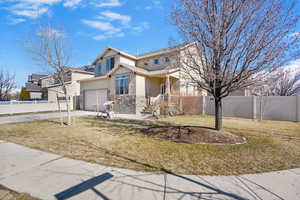 Traditional-style home with concrete driveway, stone siding, an attached garage, fence private yard, and stucco siding