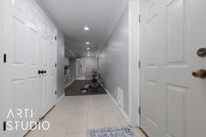 Hallway featuring recessed lighting, baseboards, and light tile patterned floors