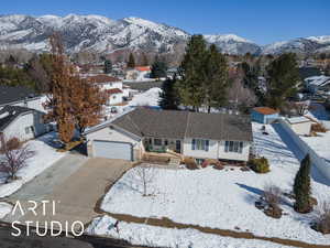 View of front facade featuring a garage, a residential view, a mountain view, and concrete driveway