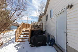 Snow covered deck with stairs and grilling area