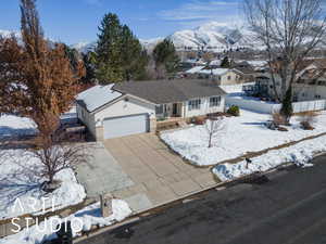 Ranch-style house with a garage, concrete driveway, brick siding, and a mountain view