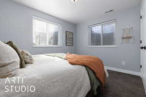 Carpeted bedroom with baseboards and visible vents