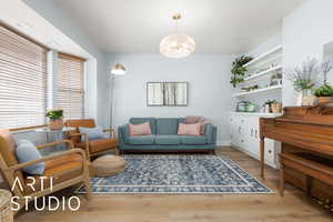 Living room with an inviting chandelier and wood finished floors