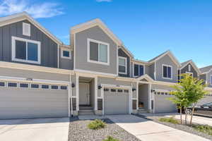 Multi unit property with driveway, an attached garage, and board and batten siding