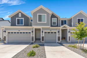 View of front facade with board and batten siding, concrete driveway, and a garage