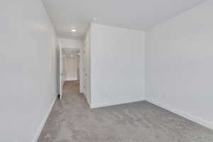 Empty room featuring light colored carpet and baseboards