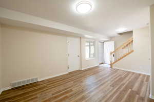 Nice sized Living room, with new window, new LVP flooring, baseboards, new carpet on stairs.