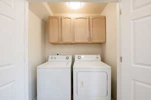 Laundry area featuring cabinet space and independent washer and dryer, on main level.