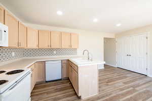 Kitchen with dining area adjacent to kitchen, with light countertops, light wood cabinetry.