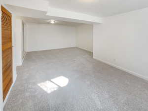 Finished below grade area featuring baseboards and light colored carpet